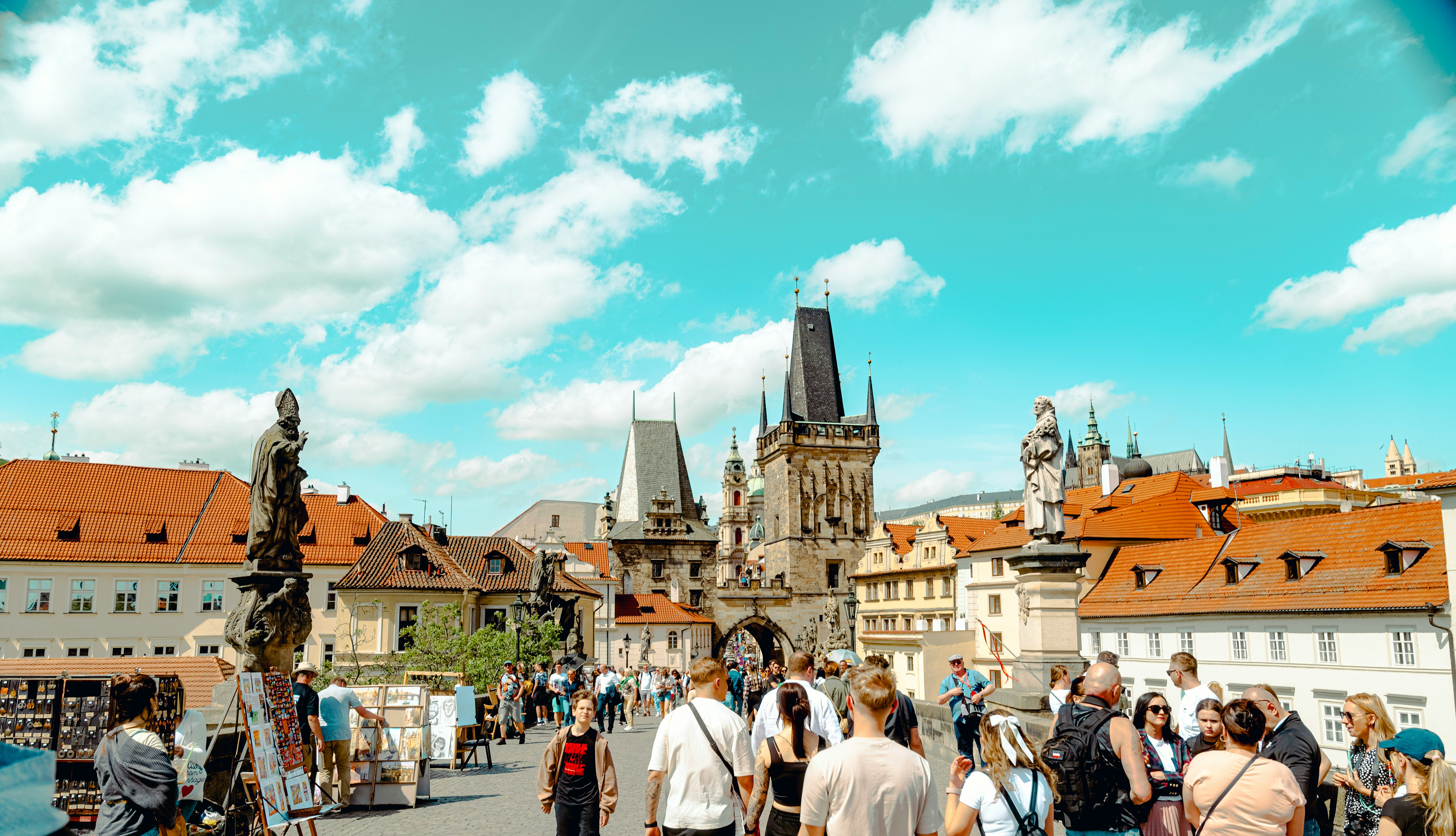 Karlsbrücke Prag — sonniger Tag mit Menschenmenge und Barockstatuen auf der Steinbrücke