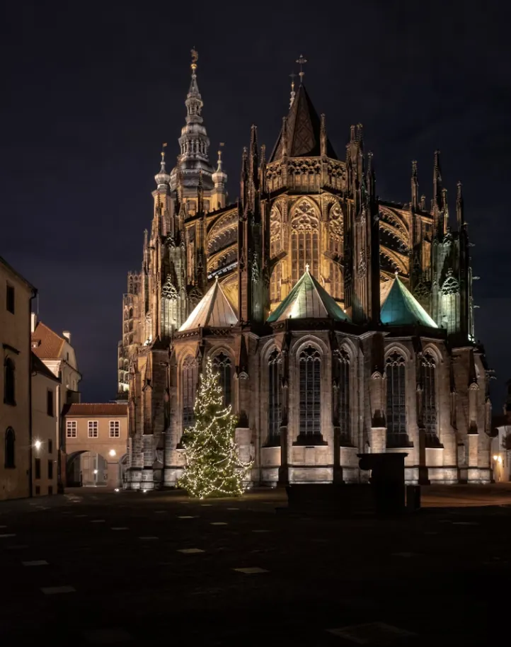 Der Chor des Veitsdoms bei Nacht, davor ein beleuchteter Weihnachtsbaum