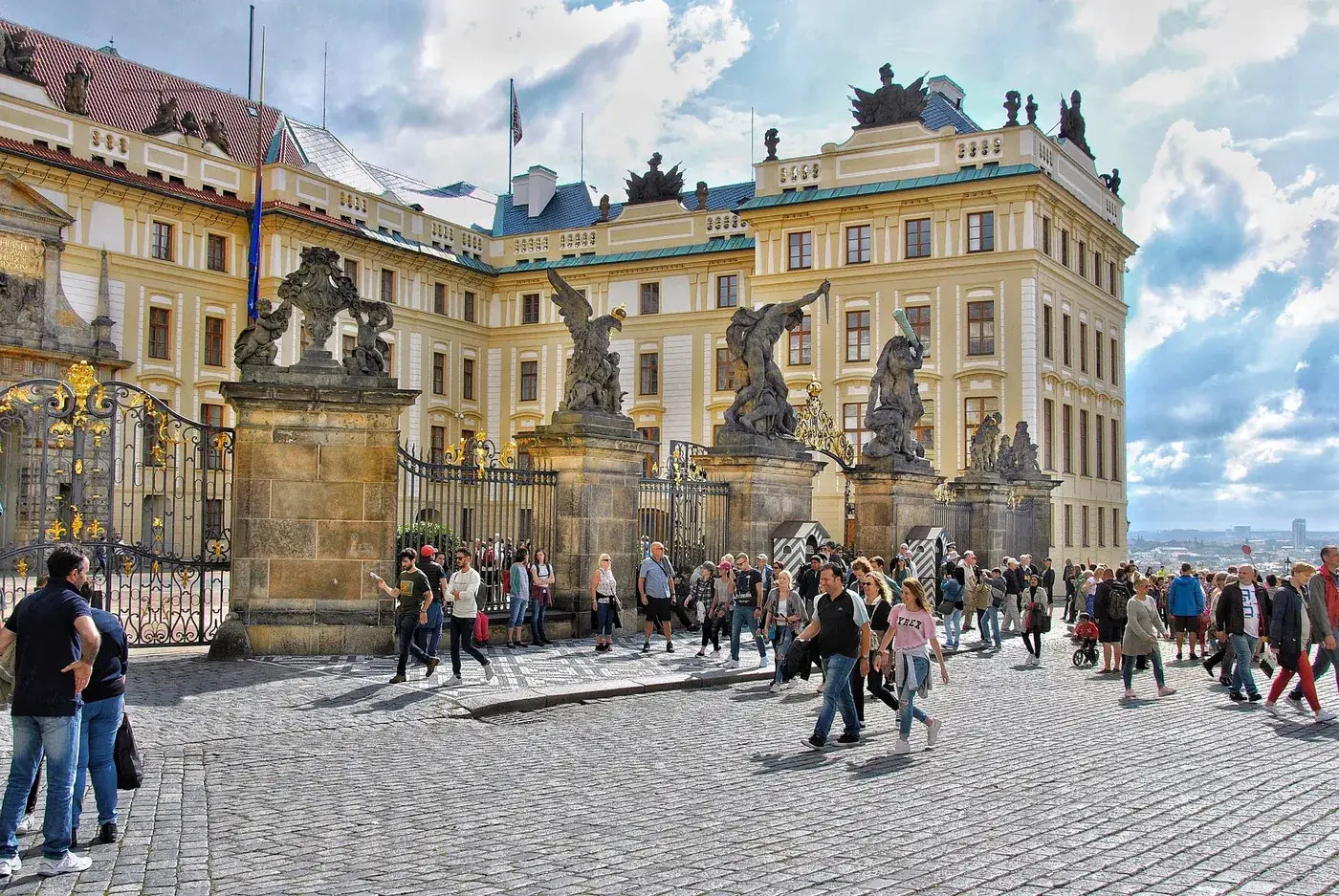 Das Haupttor der Prager Burg mit den Statuen der kämpfenden Giganten und Besuchern im Ehrenhof